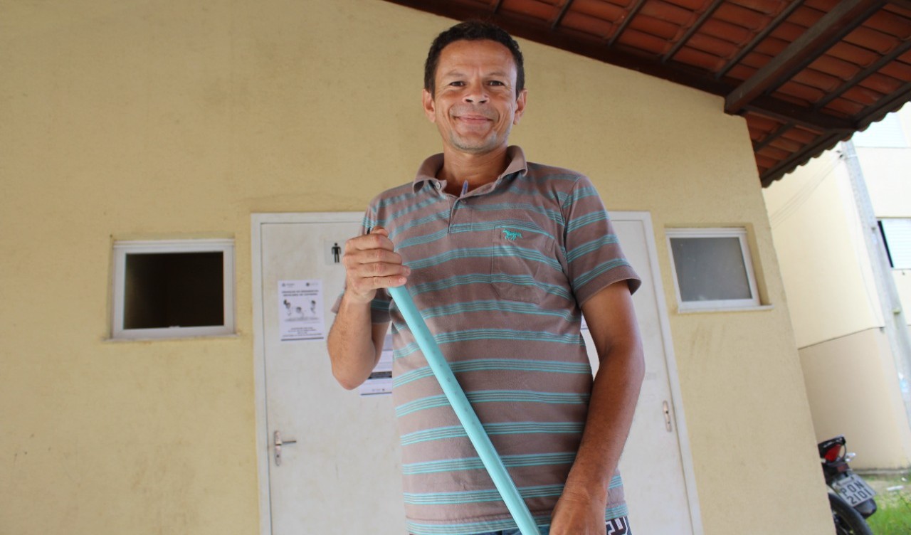 Josenildo posa para a foto segurando uma vassoura